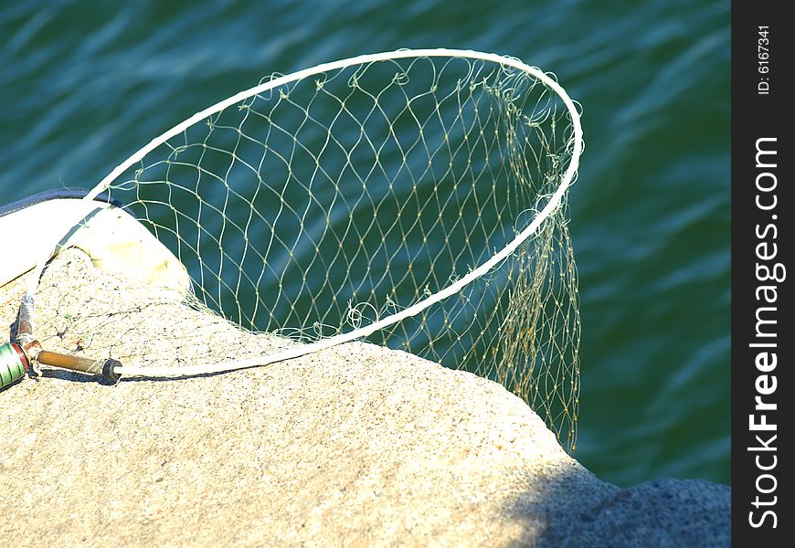 An original shot of a fishing net on a rock waiting for the fishes