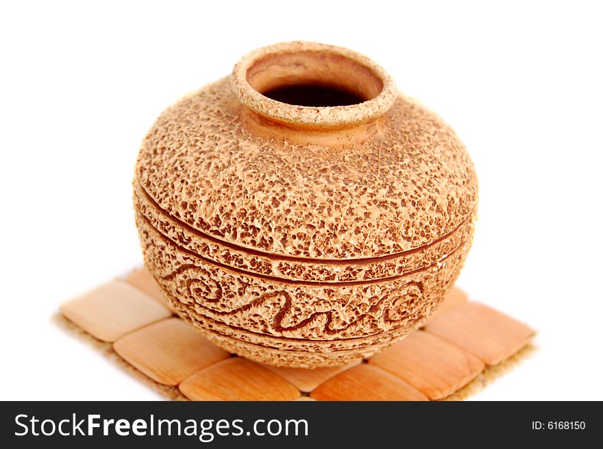 Closeup of vintage vase with rough surface over wood trivet