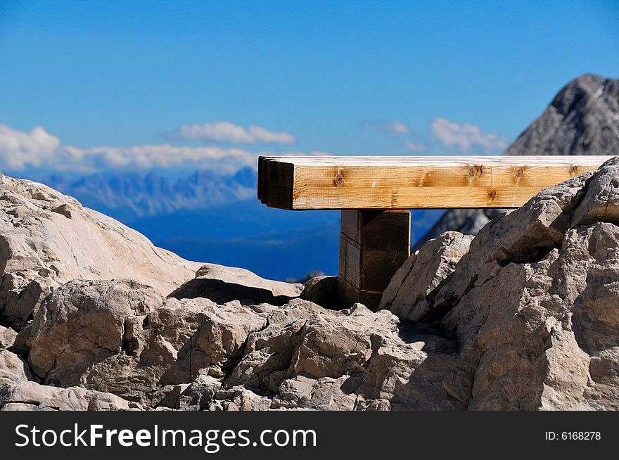 A bench beneath the Alps in a summer bright afternoon. A bench beneath the Alps in a summer bright afternoon