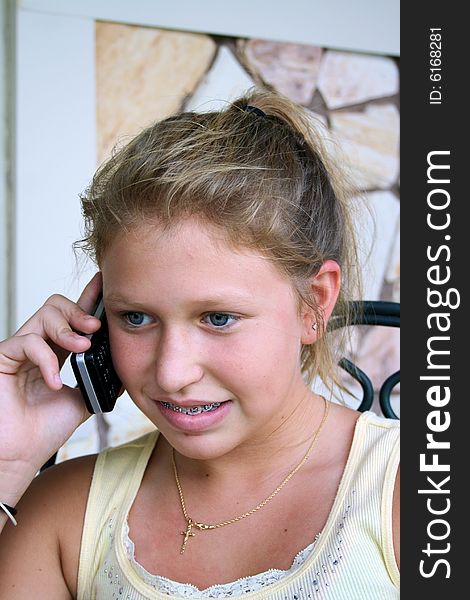 Photo of a 12 year old beautiful girl talking on her cell phone to her friends. Photo of a 12 year old beautiful girl talking on her cell phone to her friends