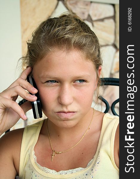 Photo of a 12 year old beautiful girl talking on her cell phone to her friends. Photo of a 12 year old beautiful girl talking on her cell phone to her friends