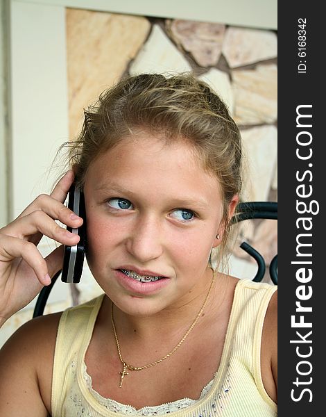 Photo of a 12 year old beautiful girl talking on her cell phone to her friends. Photo of a 12 year old beautiful girl talking on her cell phone to her friends