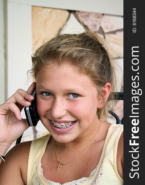 Photo of a 12 year old beautiful girl talking on her cell phone to her friends. Photo of a 12 year old beautiful girl talking on her cell phone to her friends