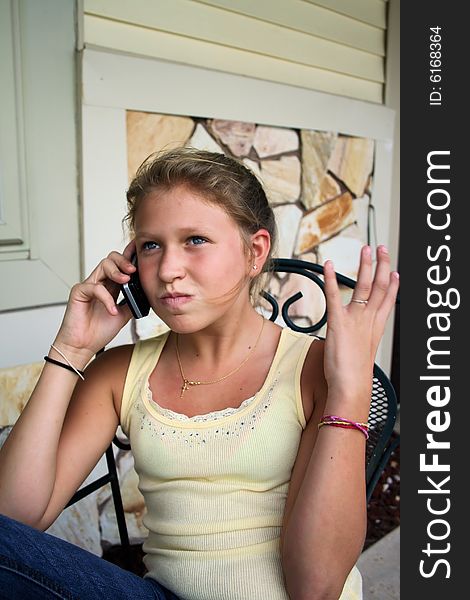 Photo of a 12 year old beautiful girl talking on her cell phone to her friends. Photo of a 12 year old beautiful girl talking on her cell phone to her friends