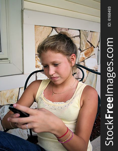 Photo of a 12 year old beautiful girl text messaging on cell phone. Photo of a 12 year old beautiful girl text messaging on cell phone