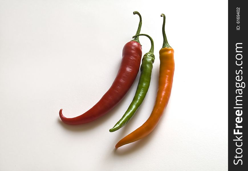 Different coloured chillies on white background. Different coloured chillies on white background