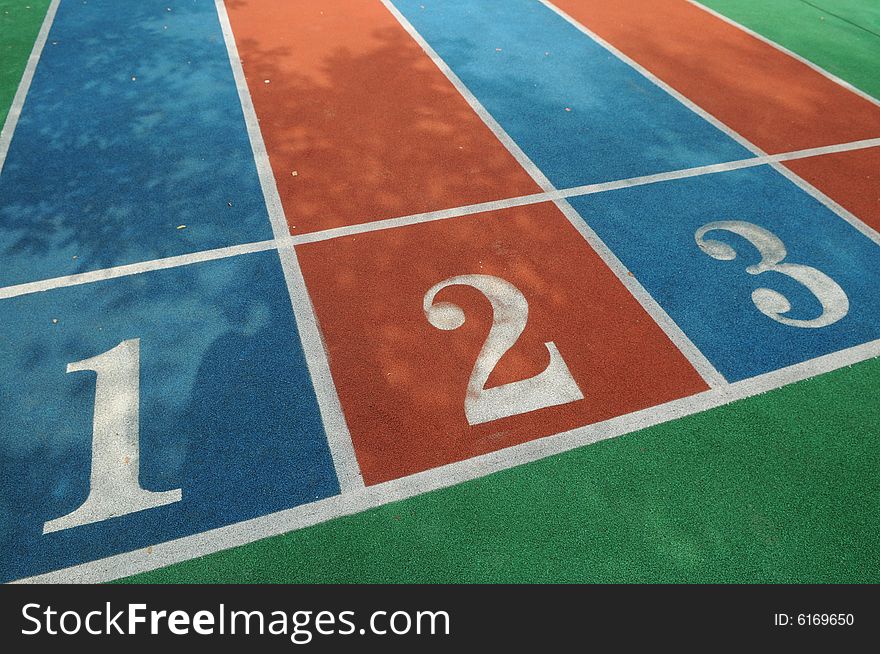 The colorful racetracks with white numbers on the playground.