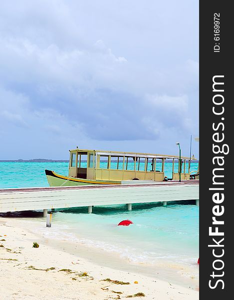 Old traditional boat anchored on a sandy beach in Maldives