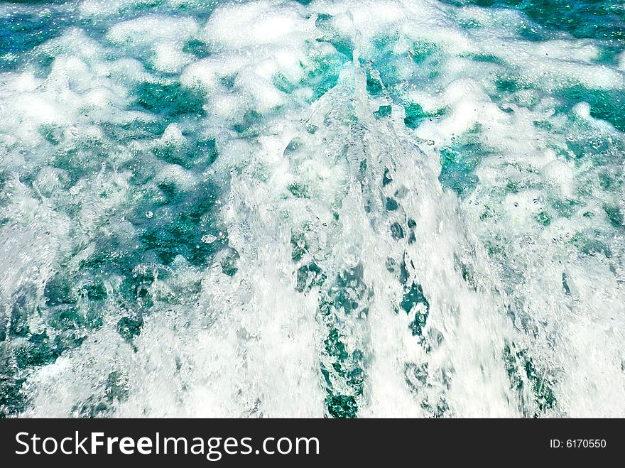 Blue water stream with white foam blue fountain. Blue water stream with white foam blue fountain