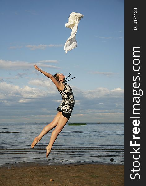 Woman jumping on the beach with white textile. Woman jumping on the beach with white textile