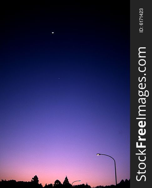 Twilight in suburban Aichi, Japan with a speck of a moon in the upper sky. Twilight in suburban Aichi, Japan with a speck of a moon in the upper sky