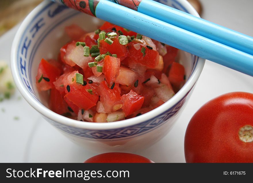A fresh salad of tomatoes with chinese table-ware