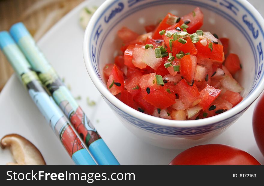 A salad of fresh tomatoes in chinese table ware