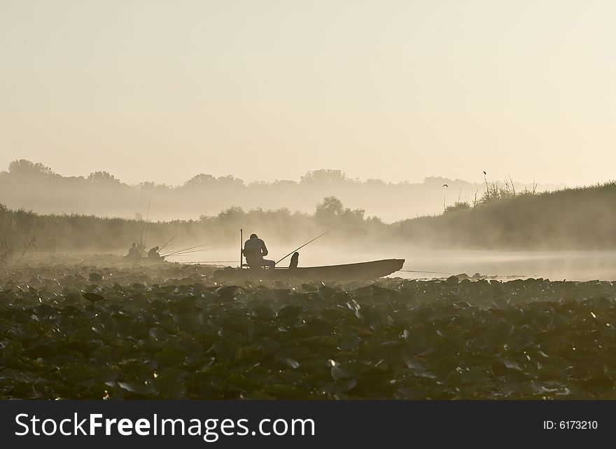 Fishermen fishing on lake with morning