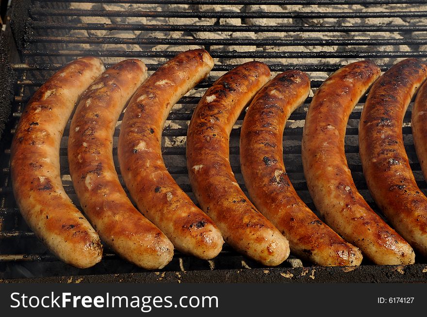 Fried sausages on barbecue with smoke of the charcoal