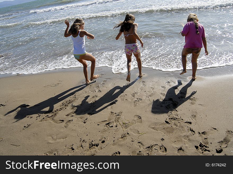 Three little girls playing and jumping on the beach. Three little girls playing and jumping on the beach