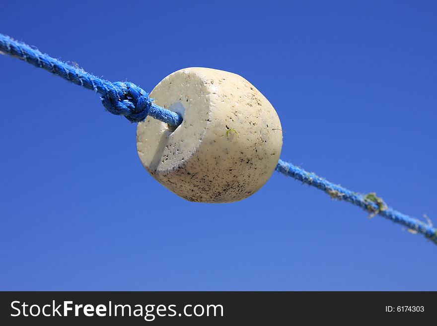 Buoys float and knot on the rope against the background of the blue sky. Buoys float and knot on the rope against the background of the blue sky.