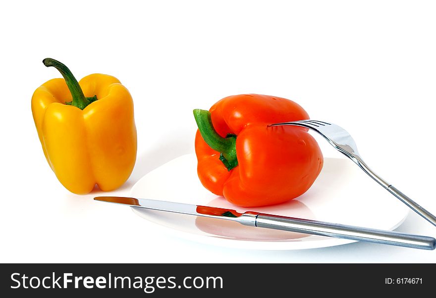 Pepper on a white plate, a knife and a fork. Pepper on a white plate, a knife and a fork