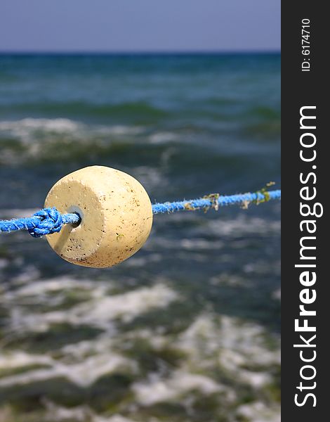 Bouys float and knot on the blue rope against the background of the sea. Bouys float and knot on the blue rope against the background of the sea.