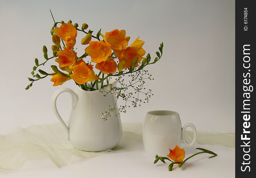 A cup yellow freesia fragrances flowers in white jug