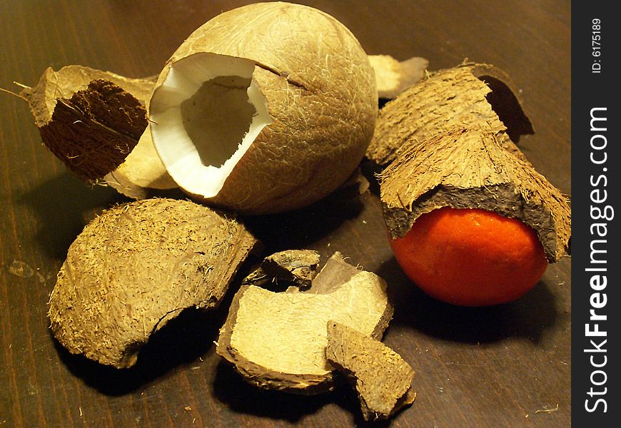 Broken coconut and a tangerine covered by shell
