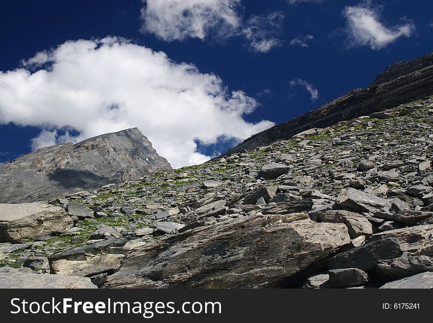 High mountain landscape with deep blue sky, clouds and many big rocks in front, horizontal. High mountain landscape with deep blue sky, clouds and many big rocks in front, horizontal