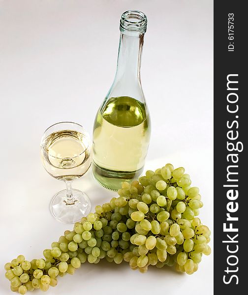 Branch of grapes and white wine in a wineglass. Isolated on White Background.