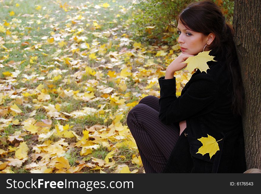 Autumn girl portrait outdoors with yellow leaf