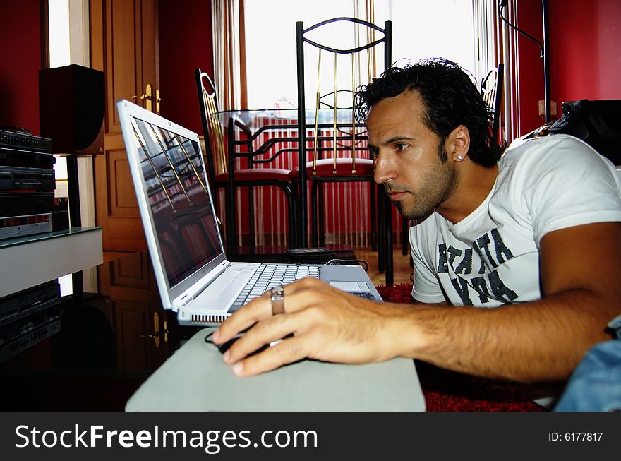 Young man with a laptop in his livingroom