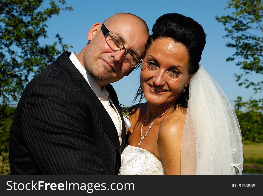 A very happy wedding couple standing close together.