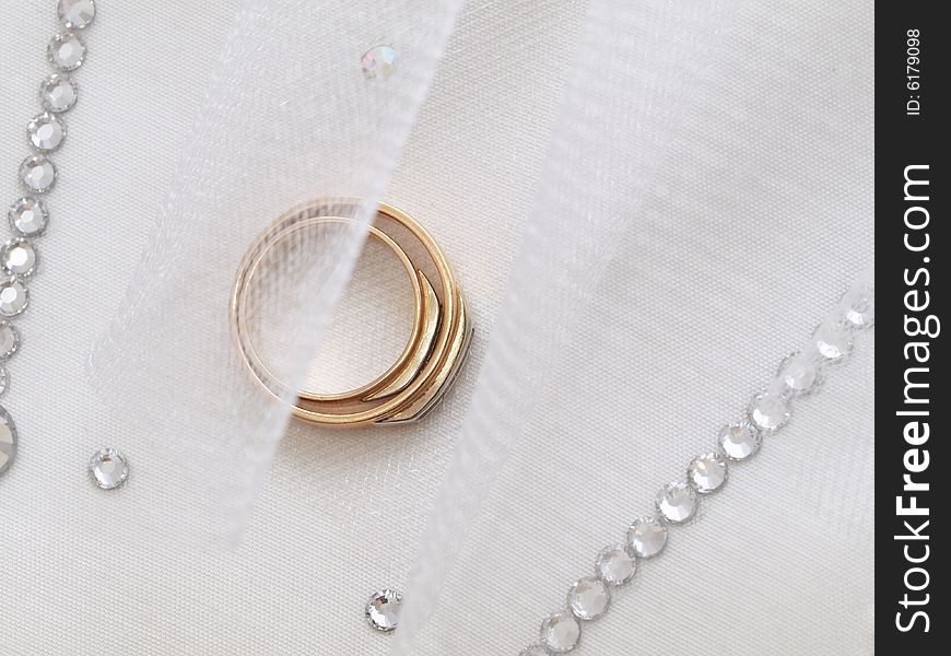 Closeup of wedding rings on a white veil