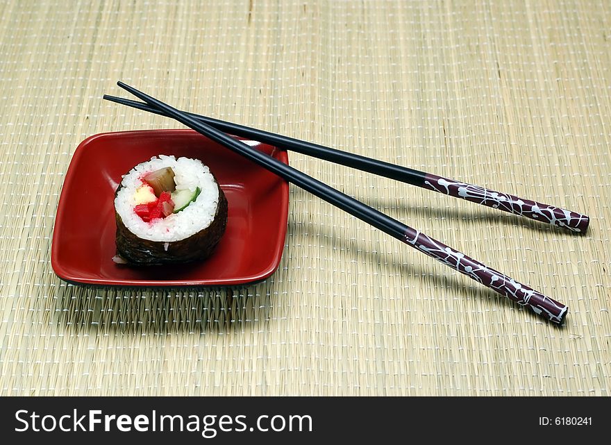 Individual Sushi in a square plate and hashi.