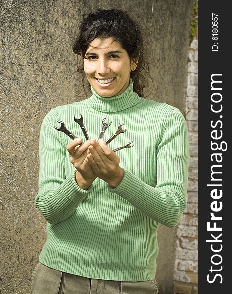 Smiling Woman Displays Wrenches - Vertical