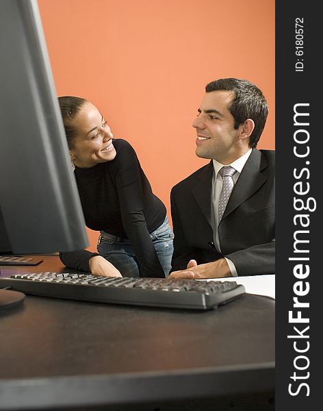 Businessman And Woman By Computer - Vertical