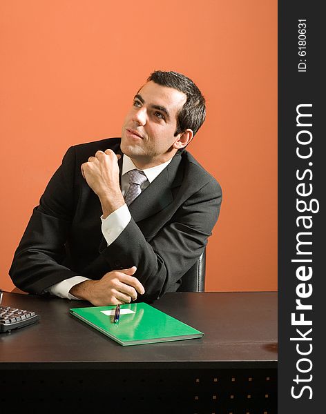 Businessman seated at desk looking at paperwork. Vertically framed photo. Businessman seated at desk looking at paperwork. Vertically framed photo.