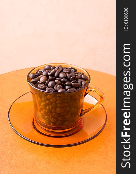 A cup with coffee beans on a table. A cup with coffee beans on a table