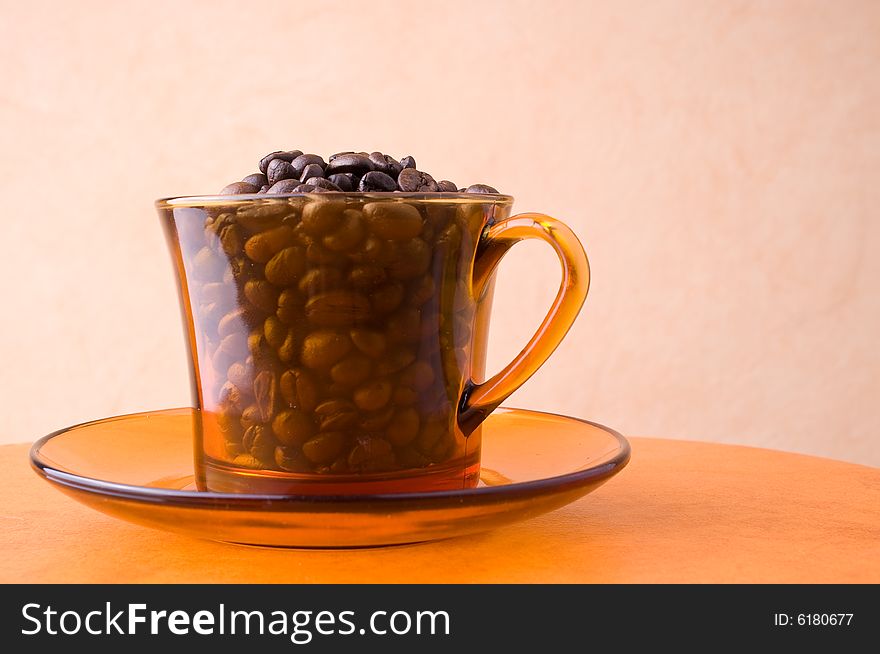 A cup with coffee beans on a table. A cup with coffee beans on a table