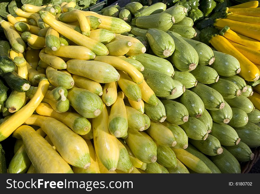 Green and yellow squash vegetables stacked at a market. Horizontally framed photo. Green and yellow squash vegetables stacked at a market. Horizontally framed photo.
