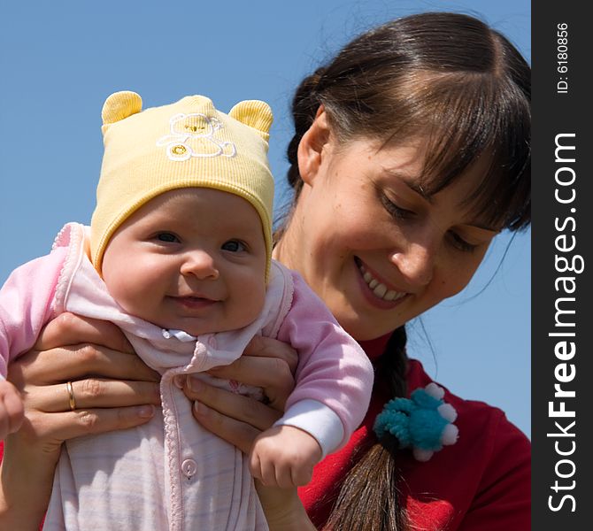 Baby with mom on blue sky background