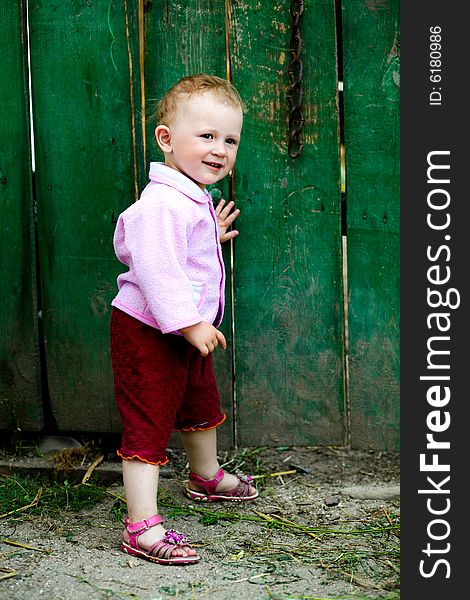 Portrait of a small girl on a background of fence. Portrait of a small girl on a background of fence