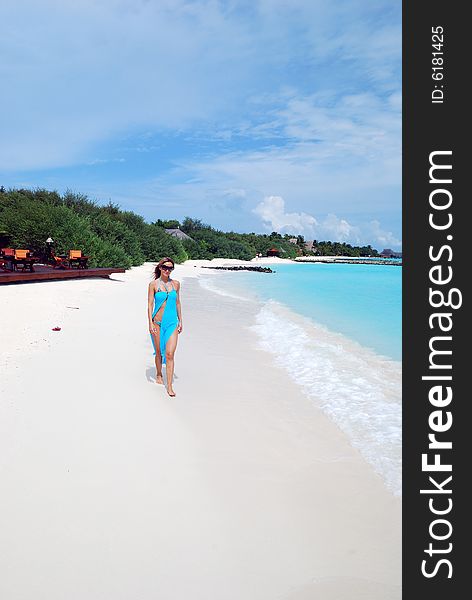 Happy woman walking on the tropical beach
