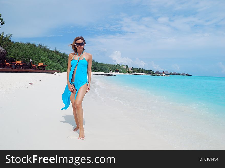 Happy woman walking on the tropical beach