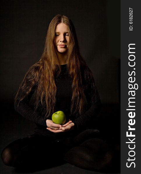 The portrait of a woman with a green apple in her hands. The portrait of a woman with a green apple in her hands