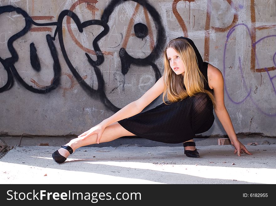 Beautiful grungy girl posing at graffiti wall. Beautiful grungy girl posing at graffiti wall