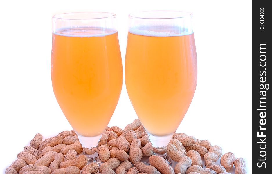 Beer in glass  and peanuts  in shells.