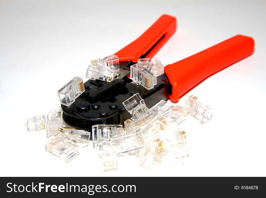 A red crimper with a few of RJ45 connectors on white background. A red crimper with a few of RJ45 connectors on white background