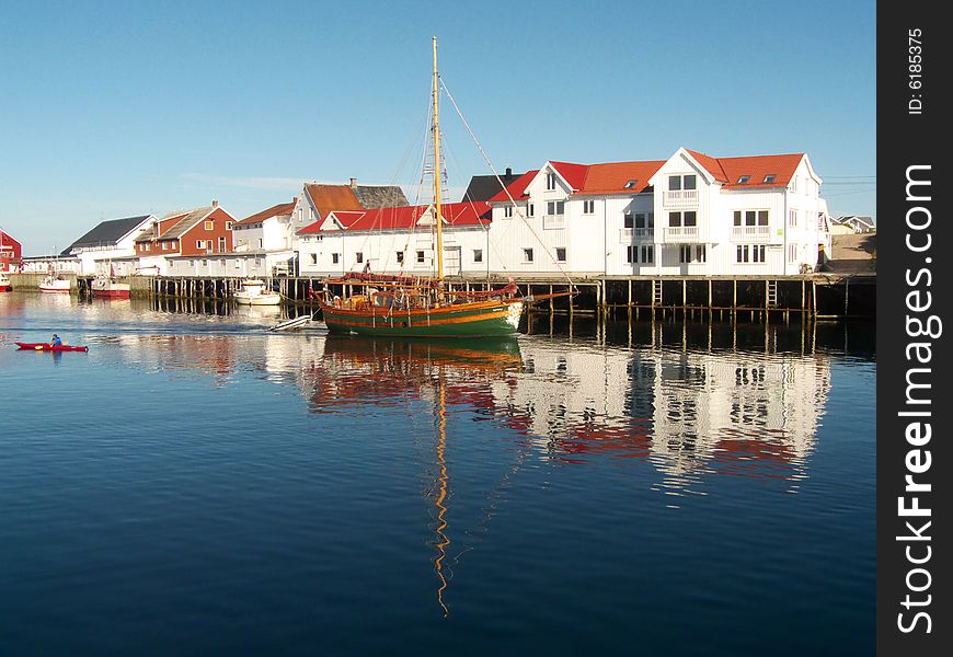 Old sailor mirroring in Henningsvaer's main channel, Lofoten islands, Norvegian arctic sea. Old sailor mirroring in Henningsvaer's main channel, Lofoten islands, Norvegian arctic sea