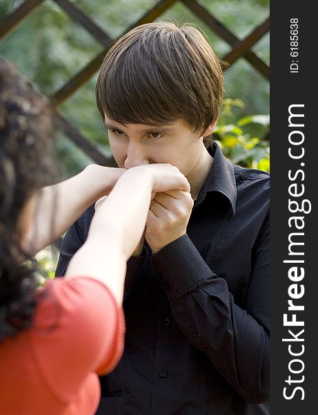 Outdoor portrait of young man kissing hands of her gilfriend