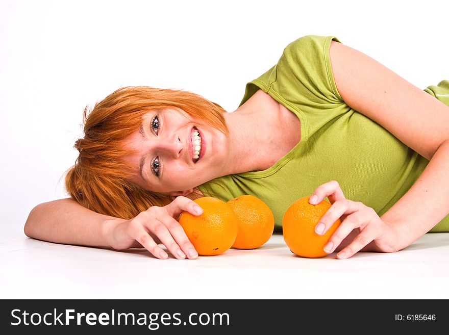 The woman lying on a white background with oranges. The woman lying on a white background with oranges