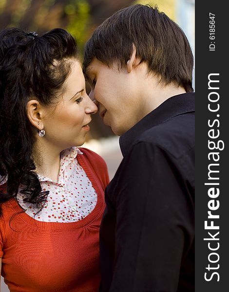 Outdoor portrait of young loving couple kissing and hugging each other